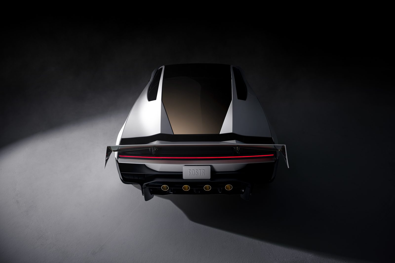 Rear of the next-generation Tesla Roadster in white, with a full-width red taillight and rear thruster nozzles