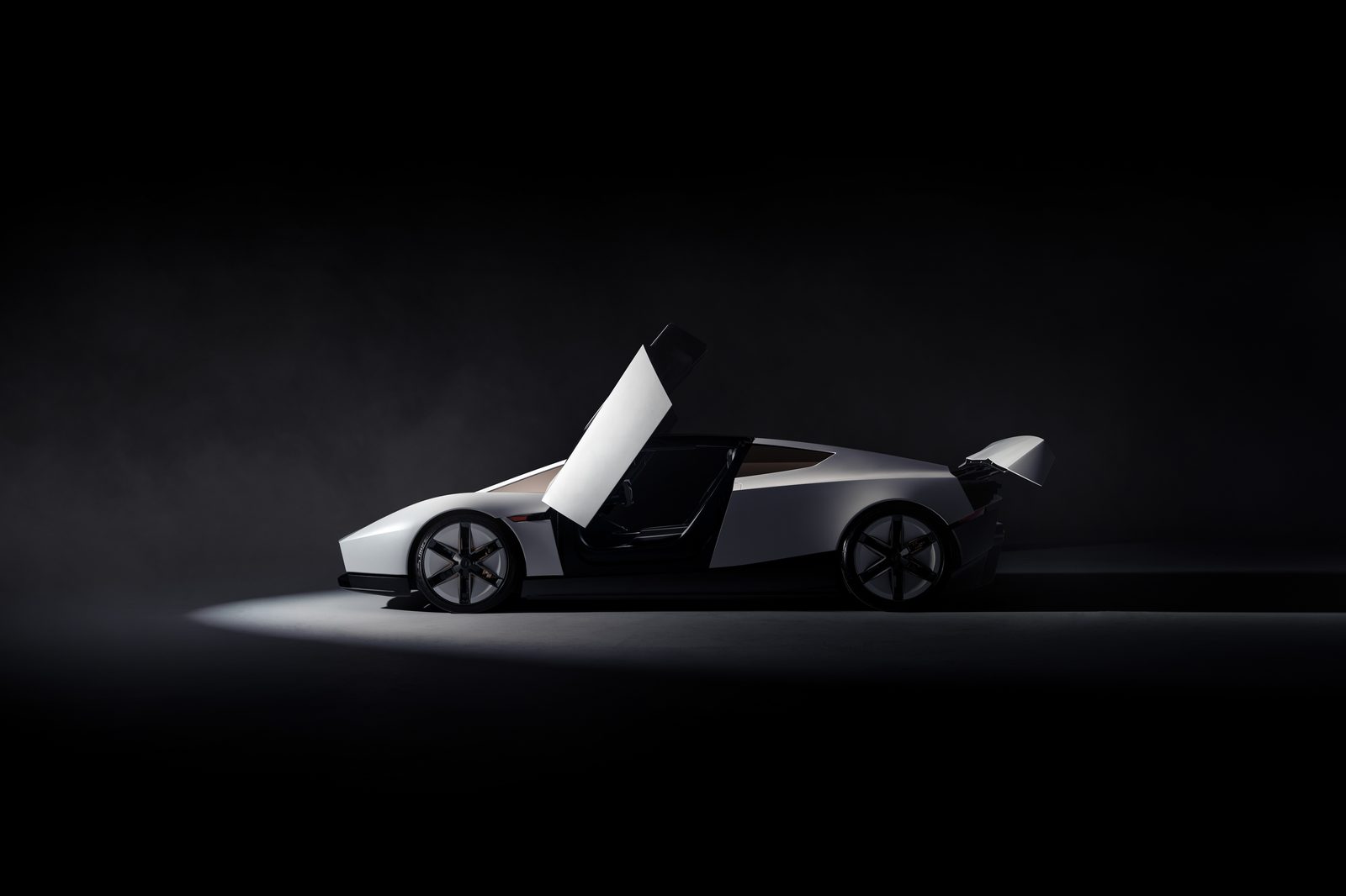 Side view of the white next-generation Tesla Roadster with its upward-opening door raised