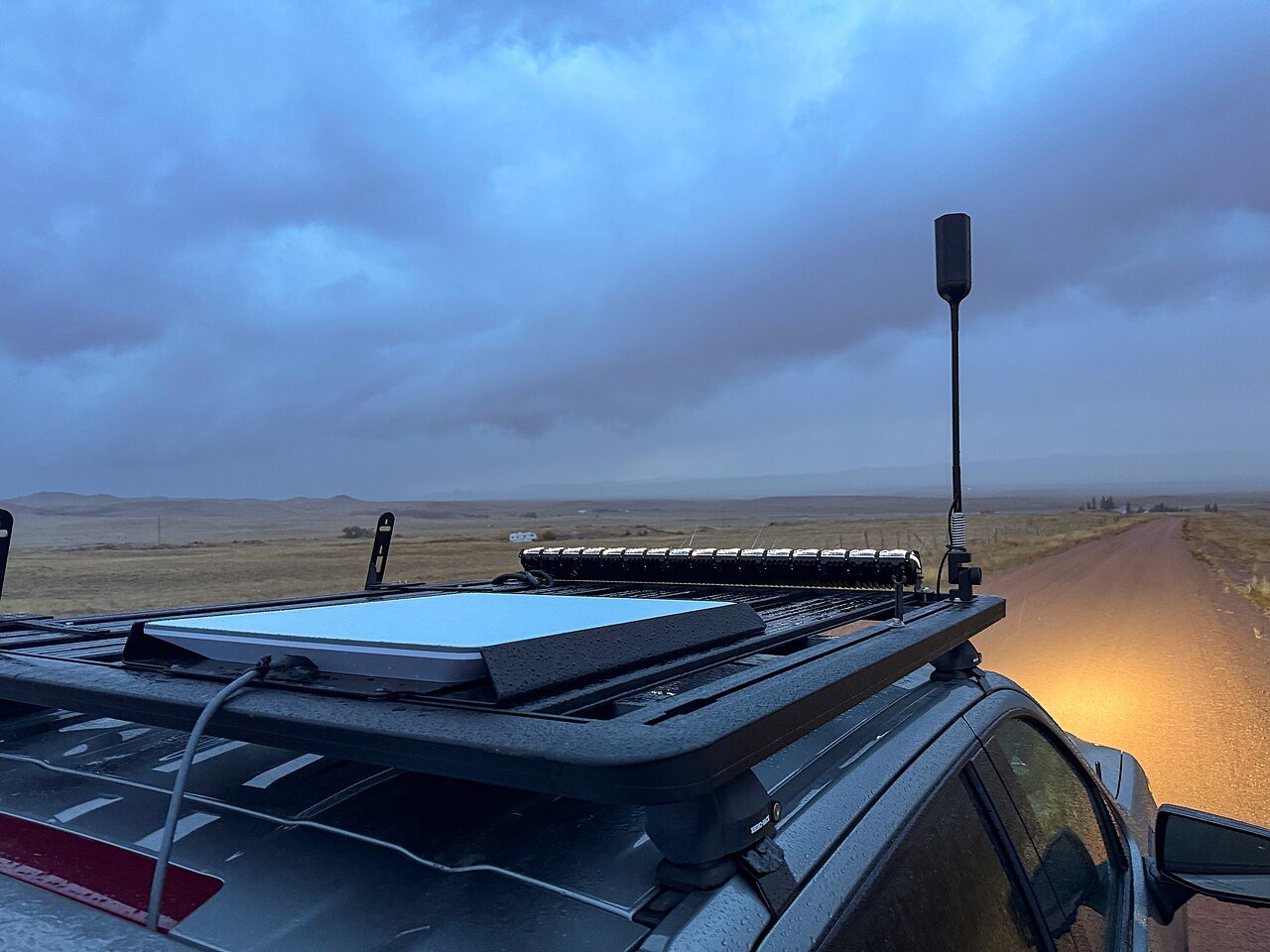 A Starlink flat panel dish mounted on the roof of an overlanding truck