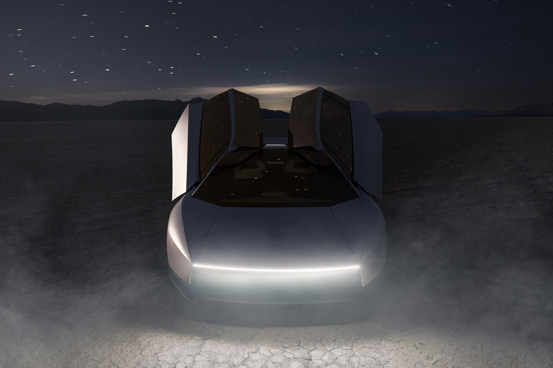 Front of the Roadster at night on a dry lakebed with both doors raised