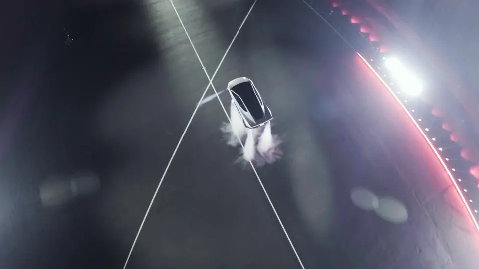 The Roadster flipping in mid-air after leaving the ramp, in a cloud of thruster gas