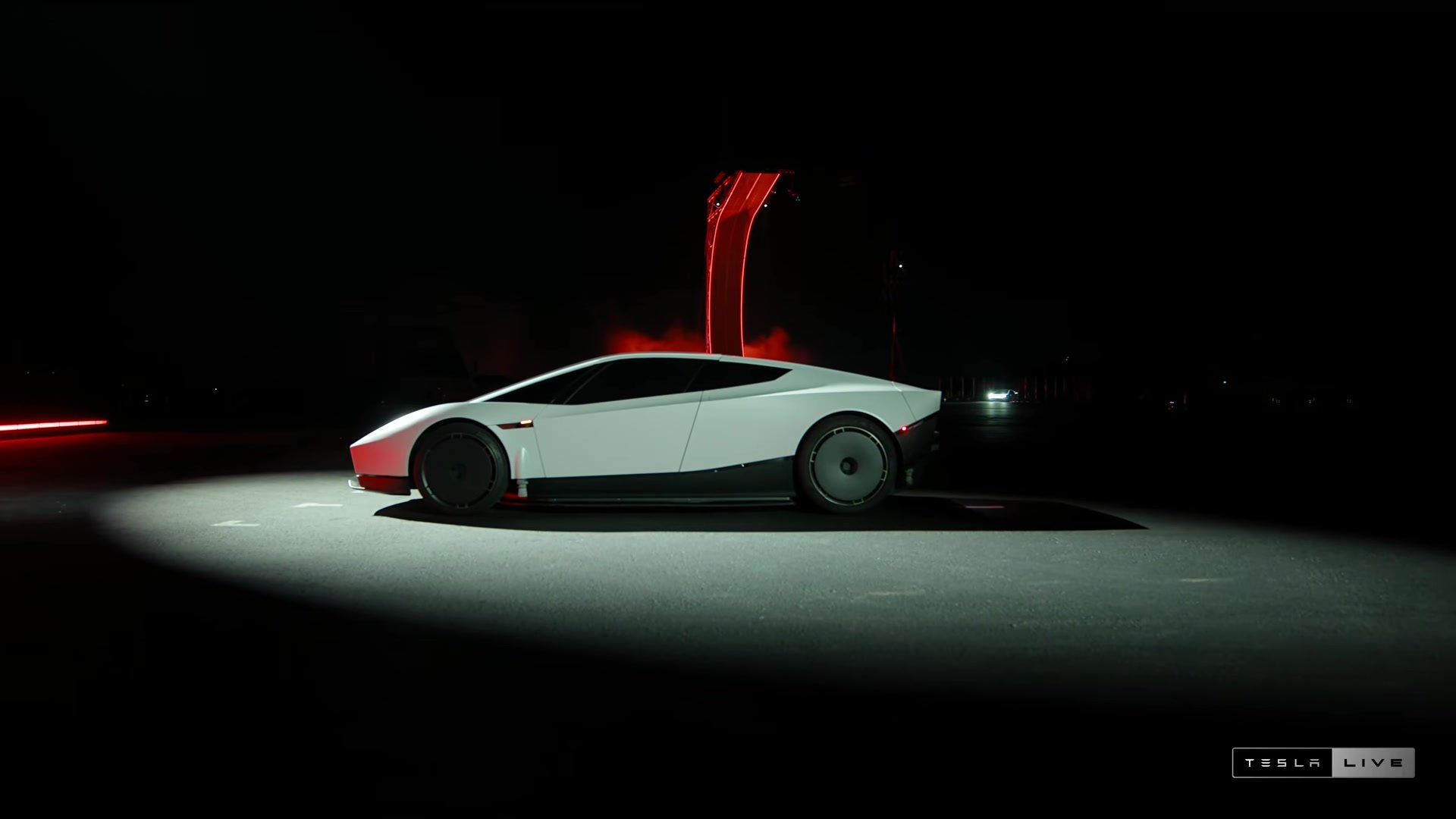 Side profile of the white next-generation Tesla Roadster on the reveal stage under a spotlight